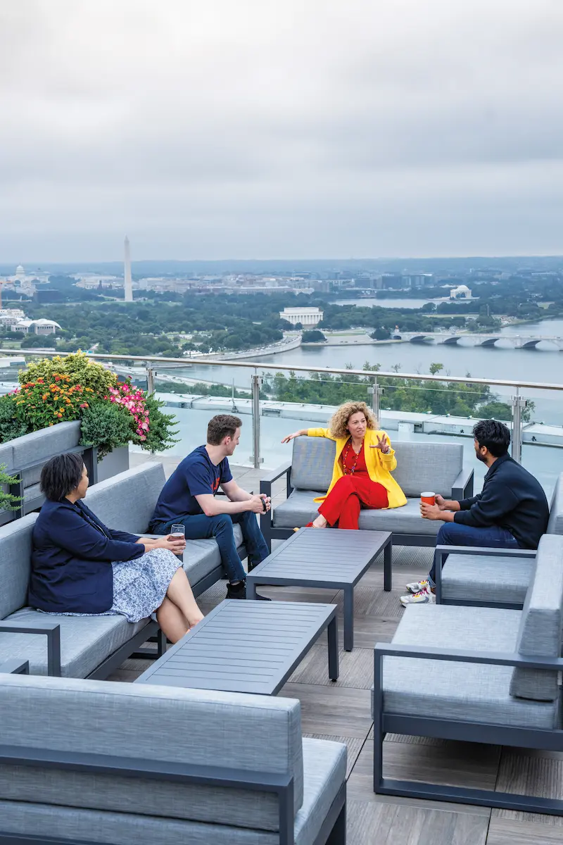 Four people having a conversation while overlooking the shores of the Potomac